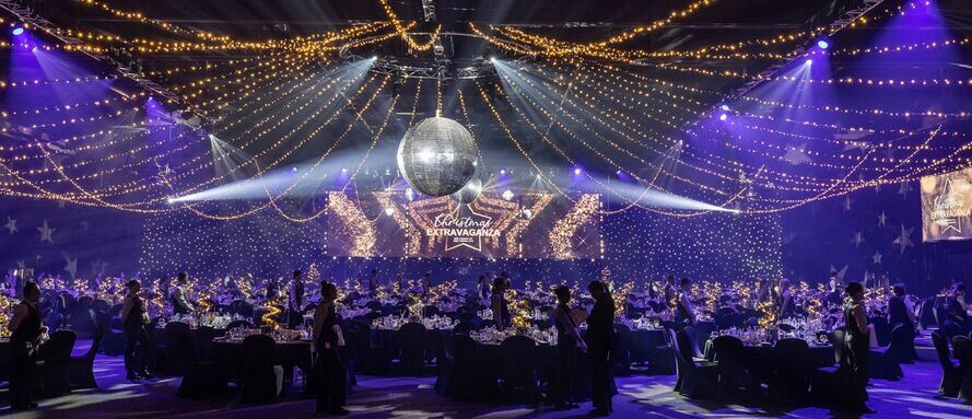 christmas-events-gold-coast Festive indoor gala for Christmas events Gold Coast with a disco ball, fairy lights, and elegant dining tables.